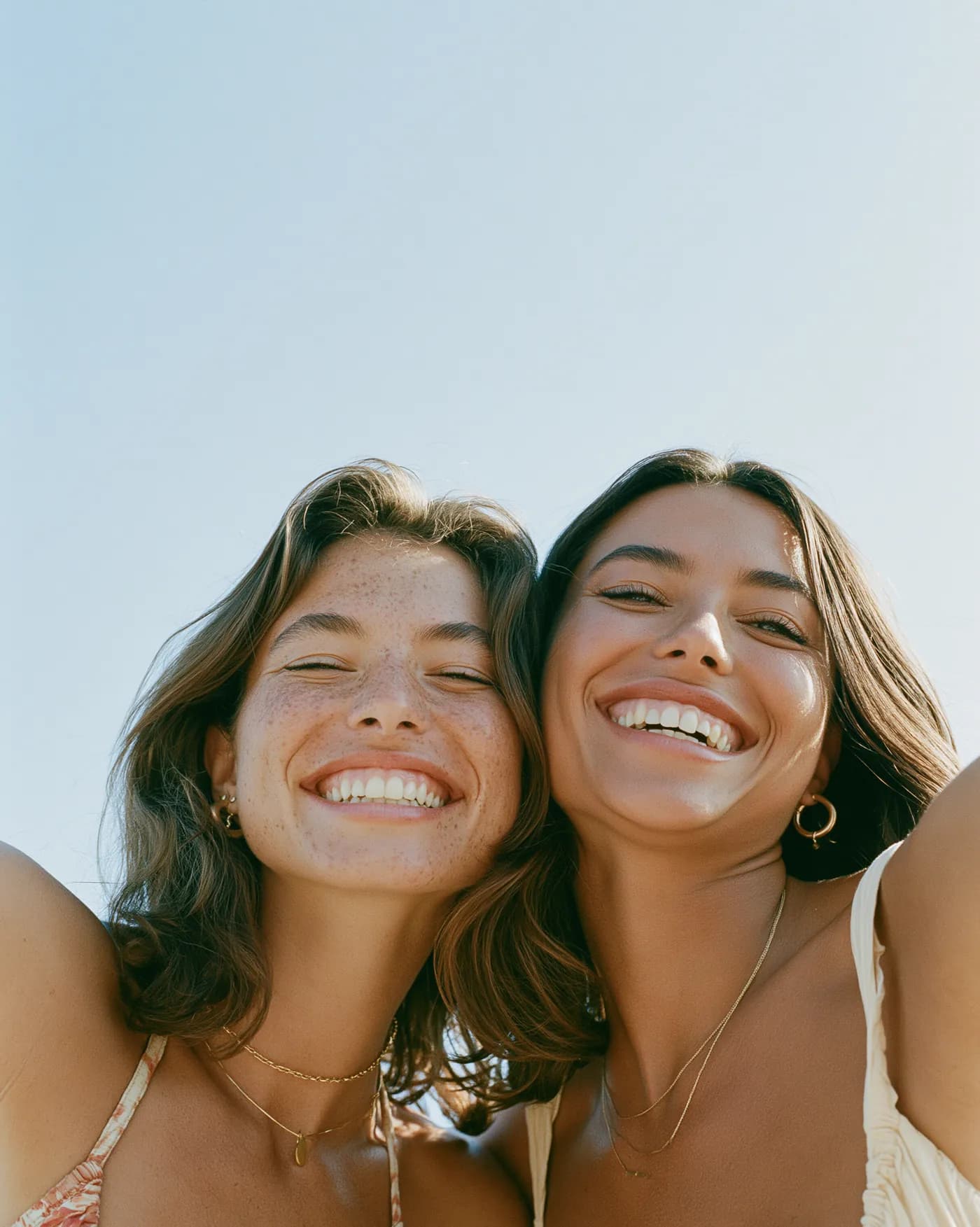 Two elegant women smiling in warm afternoon light